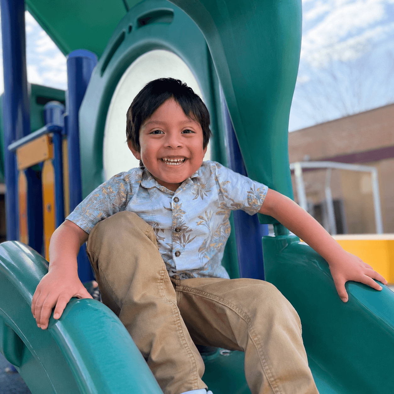 Preschooler smiling on the playground slide at Bright Beginners Academy Bensalem