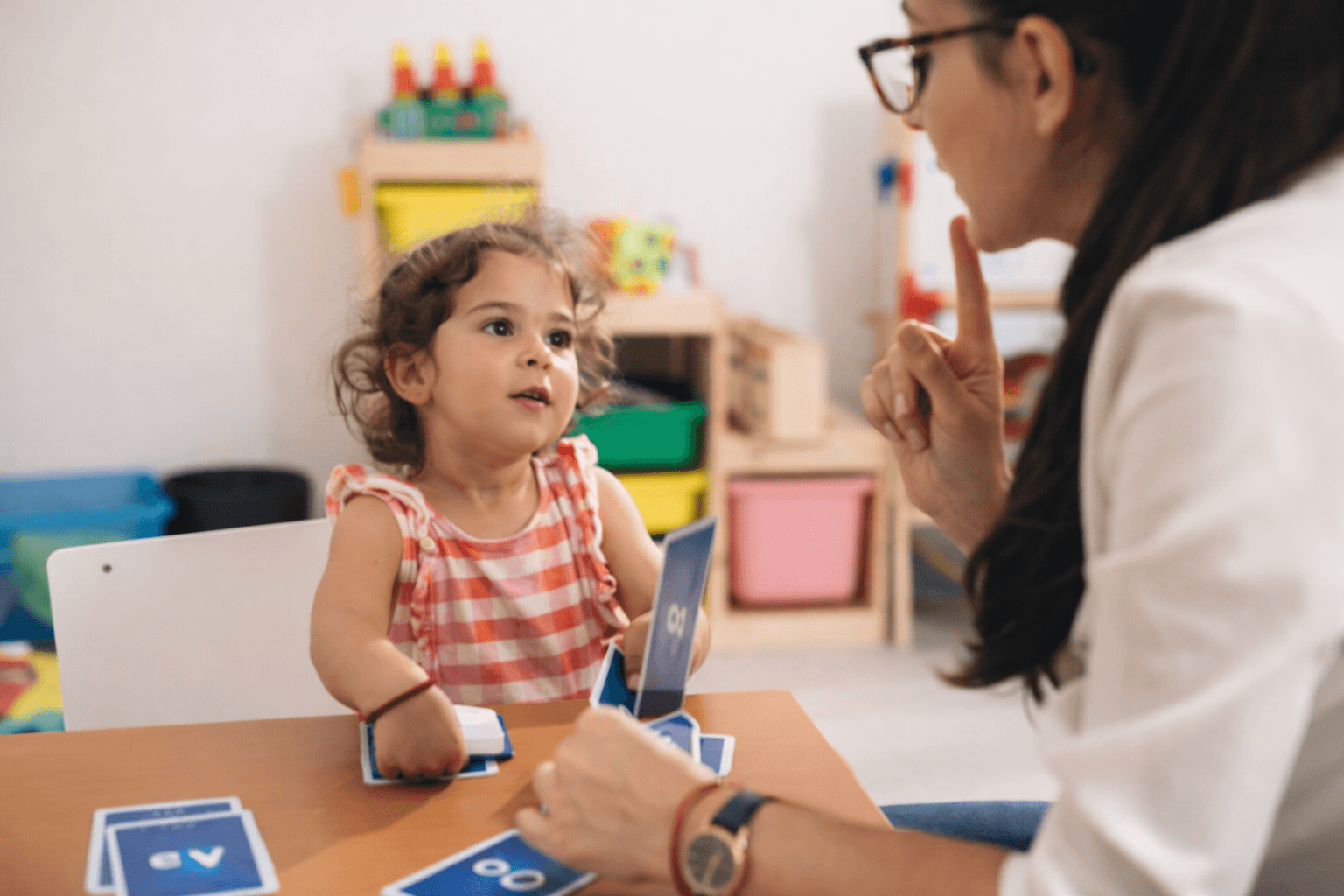 Teacher and preschooler practicing early literacy together